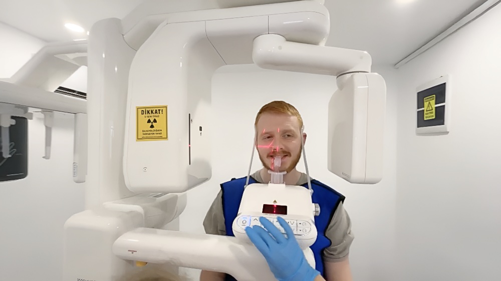Patient undergoing dental X-ray imaging with panoramic scanner at Dentatur dental clinic in Turkey.